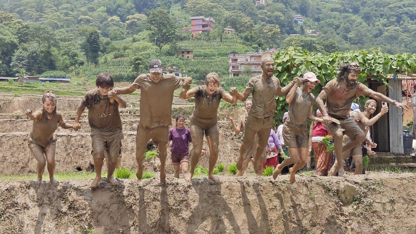 A line of people covered in mud at an obstacle race