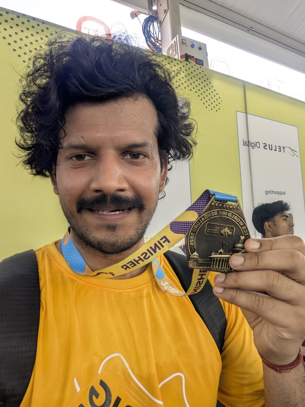 Anurag holding up a finisher medal after a race