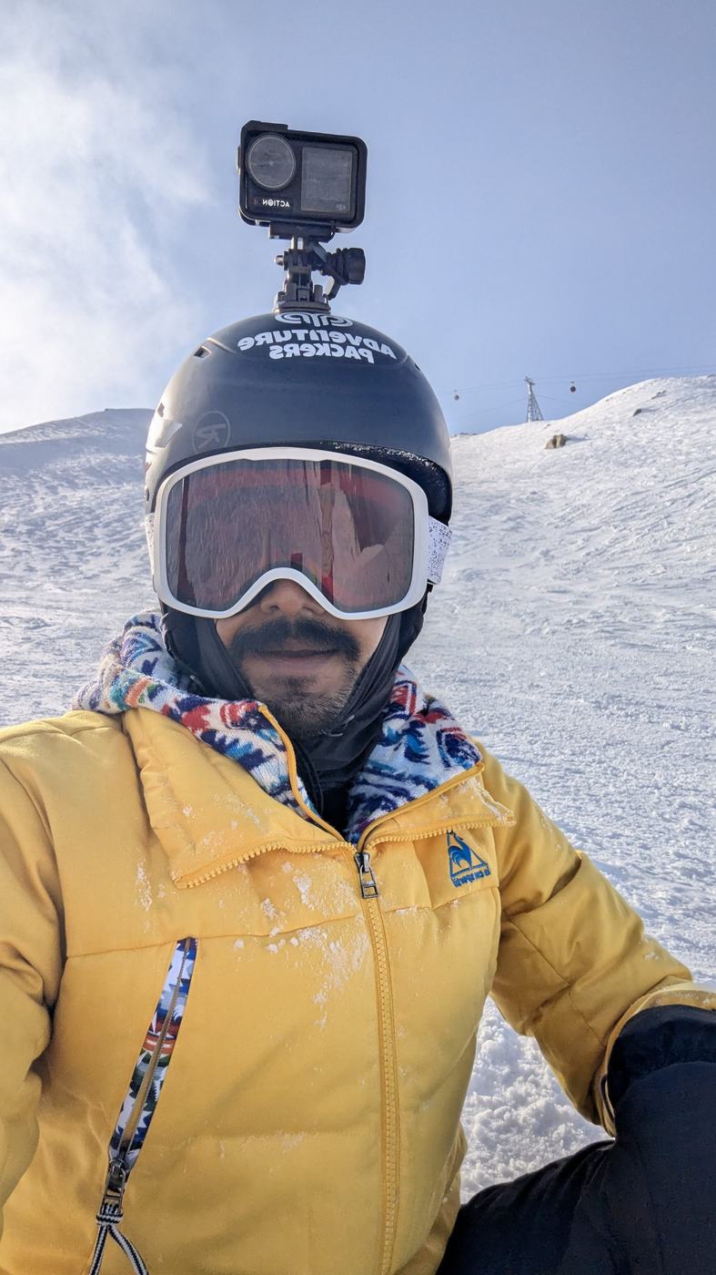 Anurag in goggles on a snowy slope with a camera on his helmet